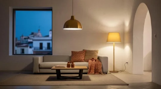 Salón de un hogar moderno español iluminado con luz LED cálida y eficiente, con arquitectura mediterránea de fondo