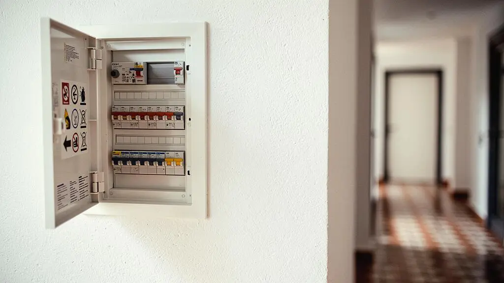 Cuadro electrico moderno con interruptores diferenciales en el pasillo de una vivienda espanola, simbolizando la seguridad electrica del hogar