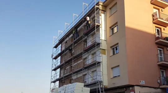 Fachada de un edificio residencial español en pleno proceso de rehabilitación energética con sistema de aislamiento térmico exterior