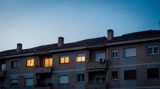 Fachada de un edificio residencial español al atardecer mostrando el contraste entre el calor interior y el frío exterior sin ningún elemento textual