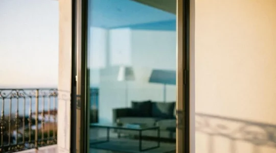 Ventana de un hogar español con vidrio bajo emisivo reflejando la cálida luz solar de invierno hacia el interior