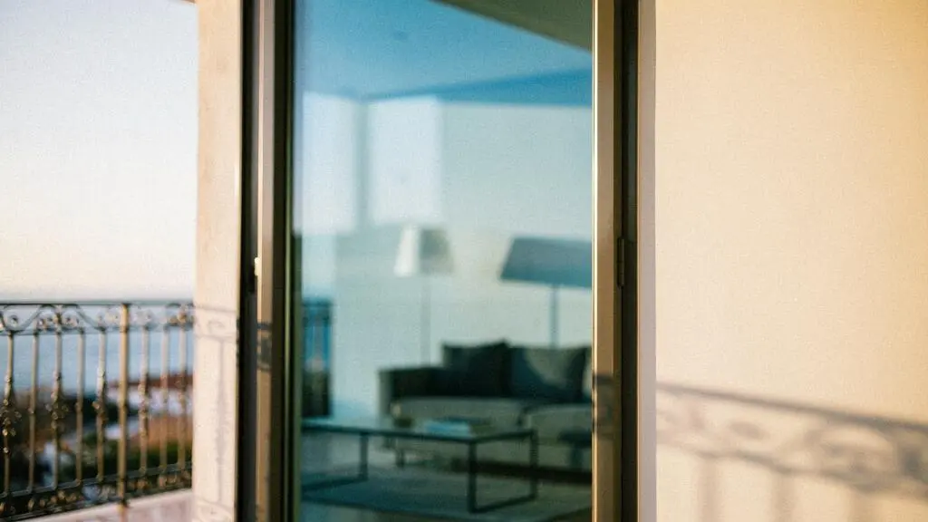 Ventana de un hogar español con vidrio bajo emisivo reflejando la cálida luz solar de invierno hacia el interior